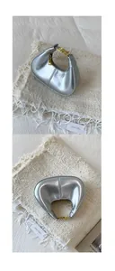 Detailansicht der silbernen Metall-Mondtasche mit goldener Schnalle und Glanz-Finish