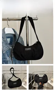 Detail of black corduroy hobo bag featuring a retro ribbed texture and fashion label