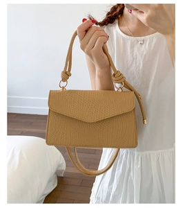 Détail du sac à main camel à texture tissée avec bandoulière nouée et accents dorés
