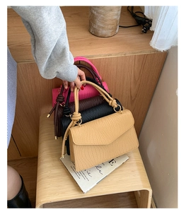 Détail de sacs à main tissés avec poignées nouées en coloris kaki noir et café foncé