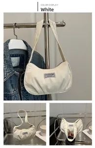 Detail view of white corduroy crescent shoulder bag with Fashion Instinct label