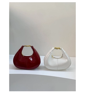 Detail of mini crescent hobo bags in glossy patent leather with gold metal hardware