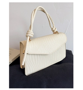 Détail du sac à main blanc cassé avec texture en V et poignée en corde tressée