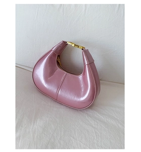 Close-up of pink patent leather half-moon bag featuring a gold rectangular metal buckle