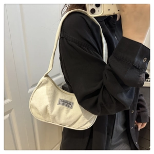 Close-up of creamy corduroy hobo bag with Fashion Instinct woven label and soft ribbed texture
