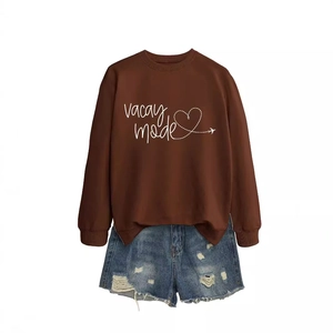 Brown long-sleeved Vacay mode sweatshirt with heart print and distressed denim shorts