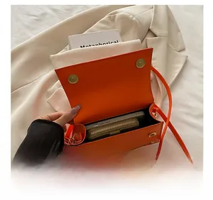 Detail van oranje leren crossbodytas interieur met ruimte voor telefoon en portemonnee