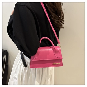 Mini sac à bandoulière en cuir rose vif porté par un mannequin pour montrer la taille