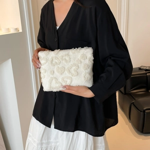 Pochette trucchi bianca in peluche con cuori indossata da modella in top nero