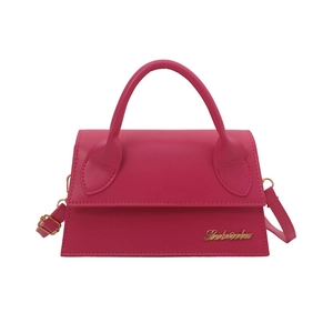 Pink minimalist trapezoid handbag with gold logo and detachable strap in front view