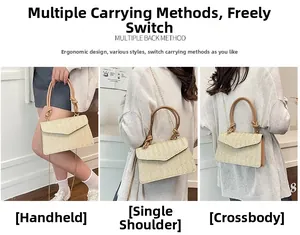 Détail du sac enveloppe en paille avec texture tressée, poignée nouée et bandoulière dorée