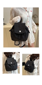 Detail of black grid pattern canvas backpack with drawstring closure and metal buckle