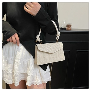 Détail du sac bandoulière tissé crème avec poignée en corde épaisse et chaîne dorée
