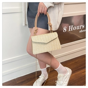 Détail du sac bandoulière en paille beige avec tissage à chevrons et poignée nouée