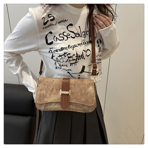 Détail du sac baguette en daim marron avec fermoir H doré et bandoulière réglable