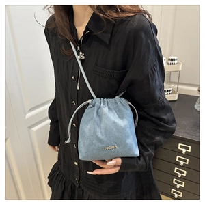 Dettaglio della borsa a secchiello in denim azzurro con chiusura a coulisse