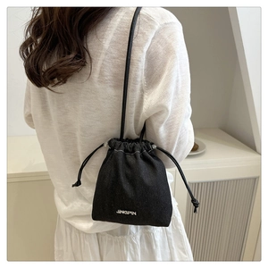 Detail of black denim bucket bag with drawstring closure and JINGPIN branding
