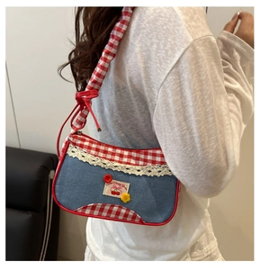 Detail of blue denim shoulder bag with red plaid trim and Sweet Cherry Garden patch