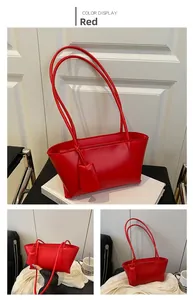 Detailed view of red retro tote bag made of glossy PU leather with shoulder straps