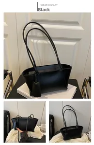 Detail of minimalist black baguette bag with elongated double straps and sleek matte leather
