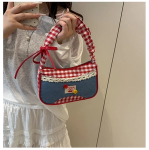 Detalle de bolso de cuadros rojos con encaje blanco y remates de mezclilla de tendencia