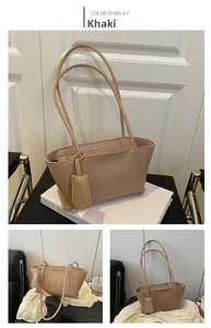 Detailed view of the khaki PU leather tote bag with long straps and matching charm pendant