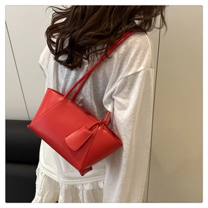 Red baguette underarm bag made of glossy leather with slim shoulder straps and tag