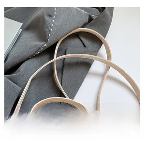Close-up of dual slender shoulder straps on a white crocodile texture tote bag
