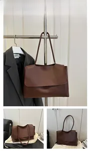 Macro detail of brown soft PU leather tote bag with flap closure and spacious interior