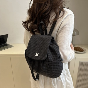 Back view of a trendy black plaid backpack with silver buckle for casual school wear