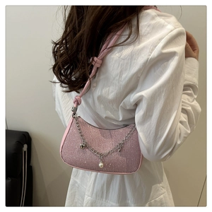 Détail du sac croissant à paillettes roses avec chaînes et breloques en cœur