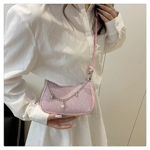 Detail of pink glitter shoulder bag with silver chain, pearls, and star charms