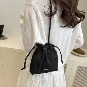 Minimalist black denim bucket bag with drawstring and metal logo for women