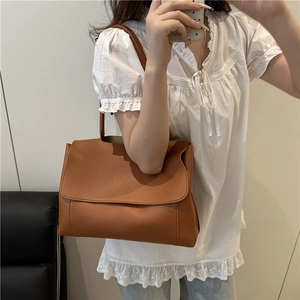 Minimalist brown PU leather tote bag with large flap shown in a mirror selfie perspective