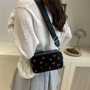 Elegant black crossbody box bag featuring red cherry prints and wide textile strap