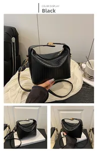 Detail view of black pleated PU leather handbag with gold-tone hardware and strap