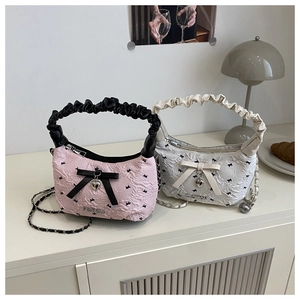 Detail of pink and white mini pillow bags featuring bow ties and heart pendants