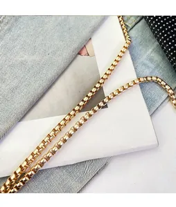 Detail of a polished gold box chain strap for crossbody bags and phone pouches