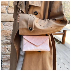 Detail of pink glitter envelope bag with fine texture and slim metal chain strap
