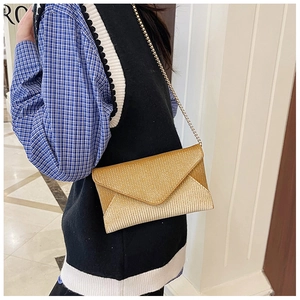 Detailed view of the gold sequin envelope bag with a delicate metallic chain strap