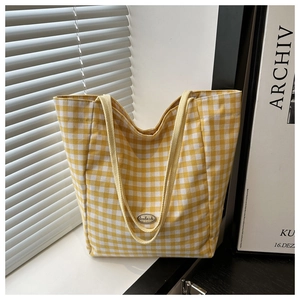 Détail du sac cabas en toile vichy jaune avec étiquette fait main sur un rebord
