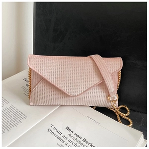 Detailed view of a pink sequin envelope bag with golden chain and glittering texture