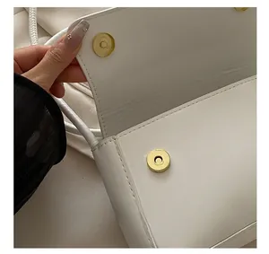 Détail de la fermeture magnétique d'un sac à bandoulière blanc en similicuir chic