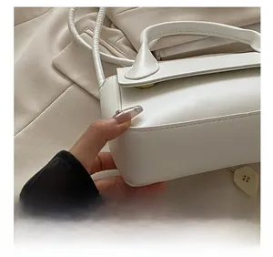 Détails rapprochés du sac en cuir blanc avec poignée ronde et fermoir magnétique doré