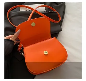 Detail of orange leather saddle bag showing interior gold magnetic snap closures