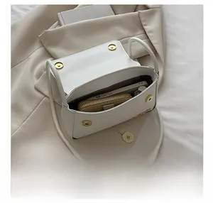 Vue intérieure d'un sac bandoulière en cuir blanc avec espace pour téléphone et portefeuille