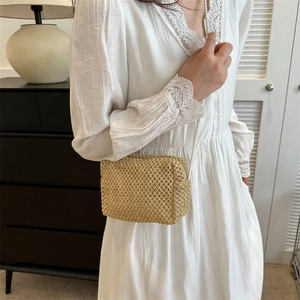 Handwoven straw crossbody bag in beige with hollow mesh texture for summer vacation