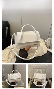 Détail du sac bandoulière en cuir blanc avec logo doré et bandoulière nouée élégante