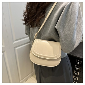 Minimalist cream white saddle bag shown on model with adjustable slim shoulder strap