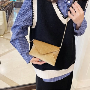 Chic gold envelope crossbody bag with a fine chain strap and shimmering metallic finish